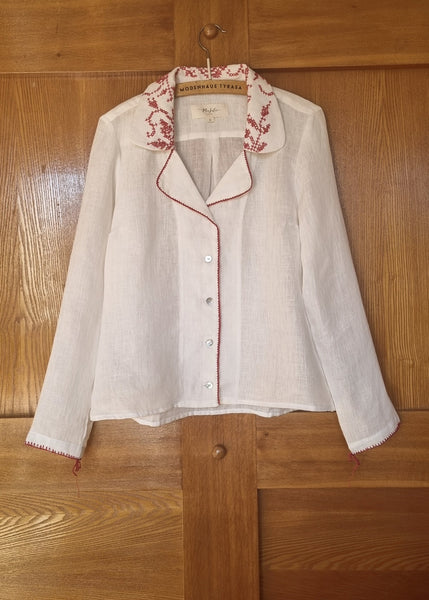 White_blouse_with_red_embroidery_on_a_wooden_surface_