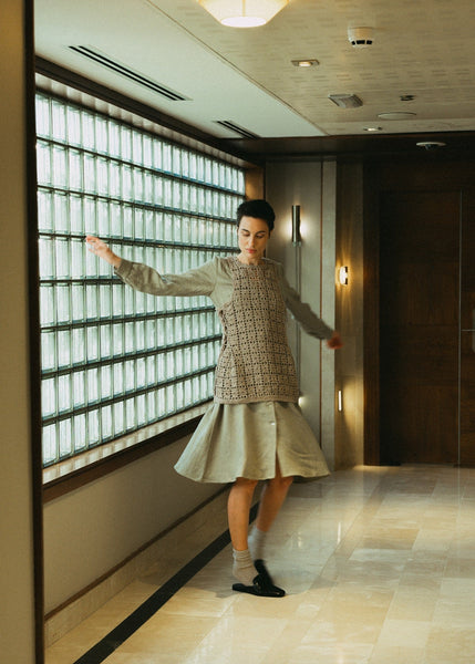Black dress with white buttons on a wooden floor